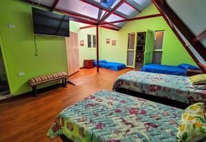a room with two beds and a flat screen tv at Clemudo Hotel Villa Colombia in Santa Rosa de Cabal