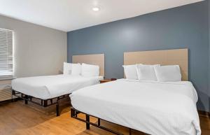 two beds in a room with blue walls at Studio 6 Extended Stay Fort Myers FL in Fort Myers