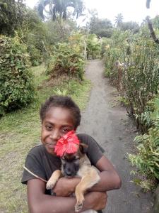 a boy holding a dog with a bow on its head at Volcano island paradise in Lénakel