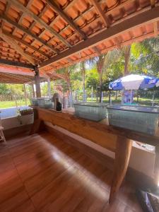 a wooden bench with an umbrella on a patio at Casa de Praia em Joanes - Salvaterra in Joanes