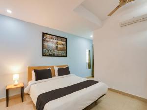 a bedroom with a large white bed and a painting on the wall at Super Townhouse Qualia Prime in Hyderabad