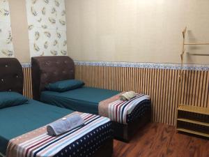 a room with two twin beds and a chair at CZ HOTEL in Pasir Puteh