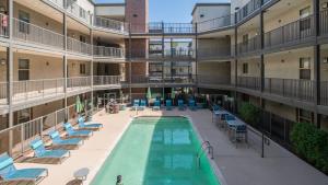 Una vista aérea de un edificio de apartamentos con piscina y sillas. en Spacious Near ASU Sloan Pk Gym Parking Pool WD, en Tempe