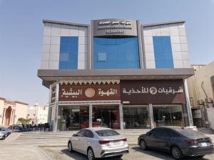 two cars parked in front of a building at شقق شذا للشقق المخدومة-درجة التصنيف-اقتصادي in Jeddah