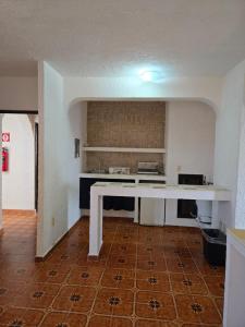 een lege keuken met een tafel in een kamer bij Íkaro Suites Cancún in Cancun