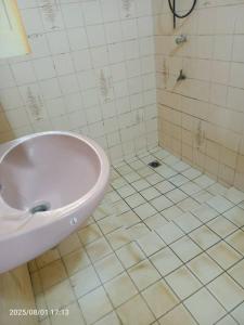 un baño con lavabo y ducha en Appartement meublé, en Lomé