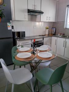 a kitchen with a table with chairs and wine glasses at SinoVilla397 in Pretoria