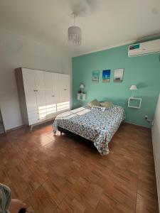 a bedroom with a bed and a wooden floor at Casa Caelum in Concepción del Uruguay +16 photos