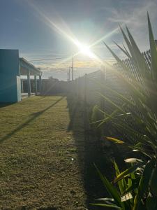 un sol brillando sobre un campo con una valla en Casa Caelum, en Concepción del Uruguay 16 fotos más