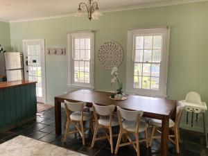 a dining room with a wooden table and chairs at Lavender Cottage in Sofala