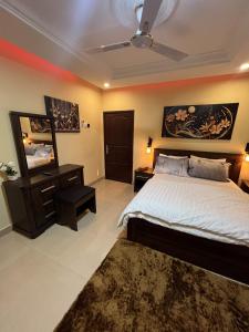 a bedroom with a bed and a dresser and a mirror at CSL Apartments in Madina