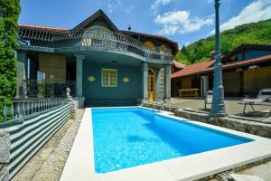 a blue swimming pool in front of a house at Family friendly house with a swimming pool Benkovec, Zagorje - 24902 in Bednja