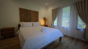 a bedroom with a large bed with two candles on it at The stones villa in Pawenang