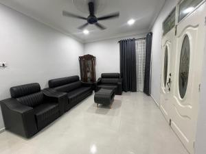 a living room with couches and a ceiling fan at Casa De Harmoni in Pasir Puteh