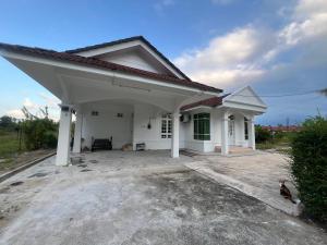a small white house with a roof at Casa De Harmoni in Pasir Puteh
