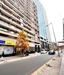 a city street with a tall building and a tree at Lubeck Suite Apartament in Santiago