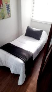 a bed with white sheets and a pillow in a room at Lubeck Suite Apartament in Santiago +15 photos