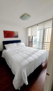 a large white bed in a bedroom with windows at Lubeck Suite Apartament in Santiago