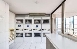 a laundry room with washing machines and a counter at Lubeck Suite Apartament in Santiago