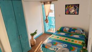 a bedroom with a bed and a window at Renacer ancestral Barú in Playa Blanca