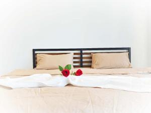 Una cama con dos rosas encima. en Sky High Harbour Bridge View - Sydney Olympic Park, en Sídney