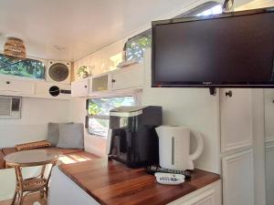 Una cocina con un televisor y una cafetera en la encimera. en Vintage Coral Green, en Nelly Bay