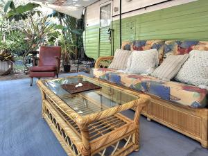 Una sala de estar con un sofá y una mesa de cristal. en Vintage Coral Green, en Nelly Bay 6 fotos más
