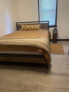 a bedroom with a bed with a blanket and a window at Little cottage by the cabin in Springfield