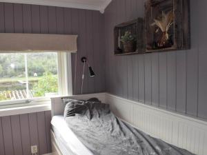 a bedroom with purple walls and a bed with a window at 4 star holiday home in SKJEBERG in Sponviken