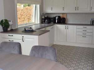 a kitchen with white cabinets and a table with two chairs at 4 star holiday home in SKJEBERG in Sponviken
