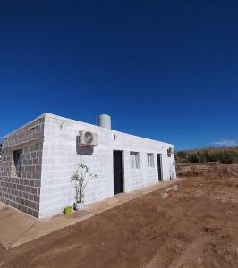 a white brick building in the middle of a field at Cabañas PAQARI in Fiambala