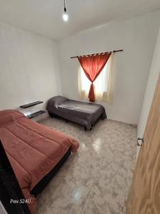 a bedroom with two beds and a window at Cabañas PAQARI in Fiambala
