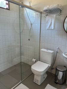 a bathroom with a toilet and a glass shower at Casa Carabinani in Novo Airão +33 photos