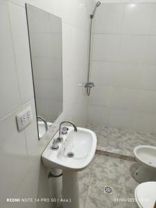 a white bathroom with a sink and a toilet at Cabañas PAQARI in Fiambala