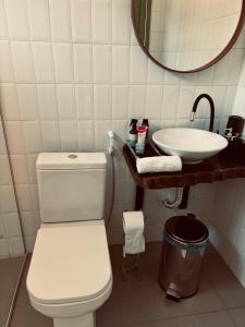 a bathroom with a white toilet and a sink at Casa Carabinani in Novo Airão