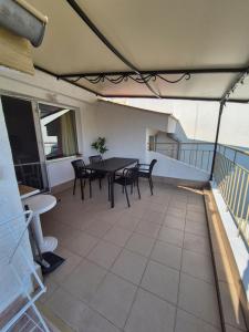 a patio with a table and chairs on a balcony at Апартамент за гости Роси in Sinemorets