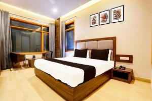 a bedroom with a large bed and a desk at Super Collection O Alwar Formerly Hotel Ashoka in Alwar