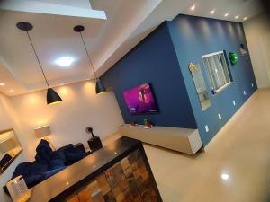 a living room with a couch and a blue wall at Casa 3 quartos com piscina próx ao Shopping in Tangara da Serra +20 photos