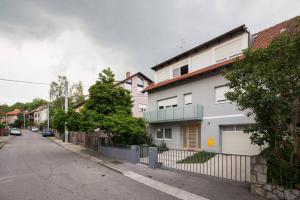 a street with a white house and a fence at Apartment Jasna in Zagreb