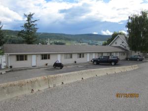 Ein weißes Gebäude mit einem LKW davor. in der Unterkunft ValleyView Motel in Williams Lake