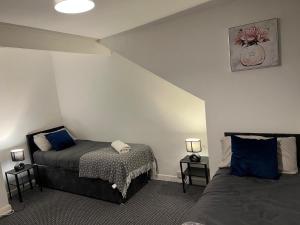 a bedroom with two beds with blue pillows at 4BR - 8 Beds - Free Parking - Long stay Discounts in Killingbeck