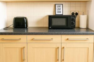 a microwave sitting on top of a kitchen counter at 4BR - 8 Beds - Free Parking - Long stay Discounts in Killingbeck +6 photos