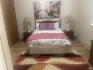 - une chambre avec un lit, deux lampes et un tapis dans l'établissement Broken Hill Desert Flower Cottage, à Broken Hill 3 autres photos