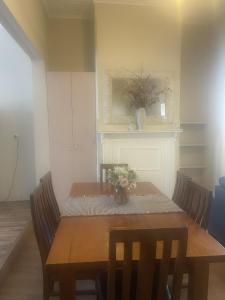 une salle à manger avec une table et des chaises en bois dans l'établissement Broken Hill Desert Flower Cottage, à Broken Hill