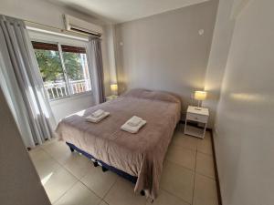 a bedroom with a bed with two towels on it at Consorcio 9 de Julio in San Juan