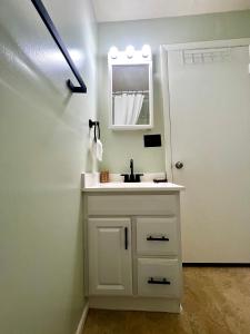 Un baño blanco con lavabo y espejo. en Guest Studio, en Gainesville