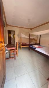 a room with two bunk beds and a table at Highland hotel kapchorwa in Kapchorwa