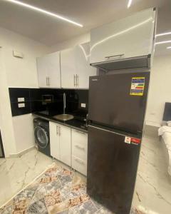 a kitchen with a black refrigerator and a sink at Princess Resort hurghada in Hurghada +7 photos