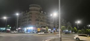 een groot gebouw met auto's geparkeerd op een parkeerplaats 's nachts bij Vista Studio Apartment in Brčko