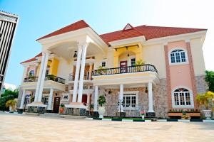 a large yellow and pink house at 5 Star Villa Hotel in Trofwi